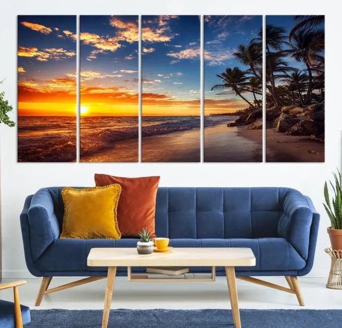 A living room featuring the Tropical Island Wall Art Canvas Print Sunset Artwork Print, a triptych displaying a beach sunset on museum-quality canvas with UV-protective coating, is prepared to hang.