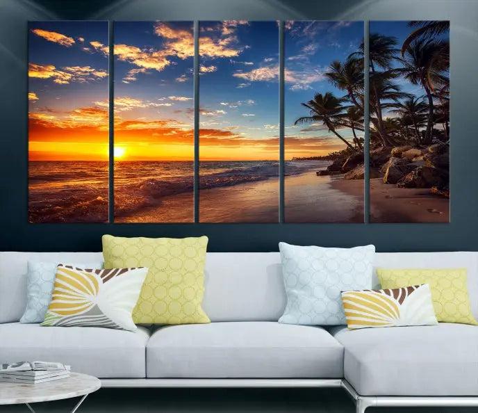 A living room featuring the Tropical Island Wall Art Canvas Print Sunset Artwork Print, a triptych displaying a beach sunset on museum-quality canvas with UV-protective coating, is prepared to hang.