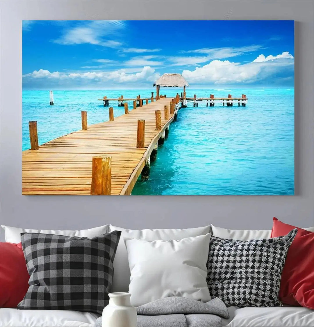 The Tropical Pier Triptych Wall Art is a captivating canvas print featuring a turquoise ocean and a wooden dock, ideal for coastal beach house decor.