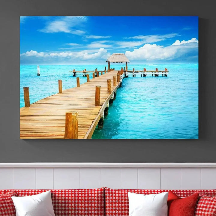 The Tropical Pier Triptych Wall Art is a captivating canvas print featuring a turquoise ocean and a wooden dock, ideal for coastal beach house decor.