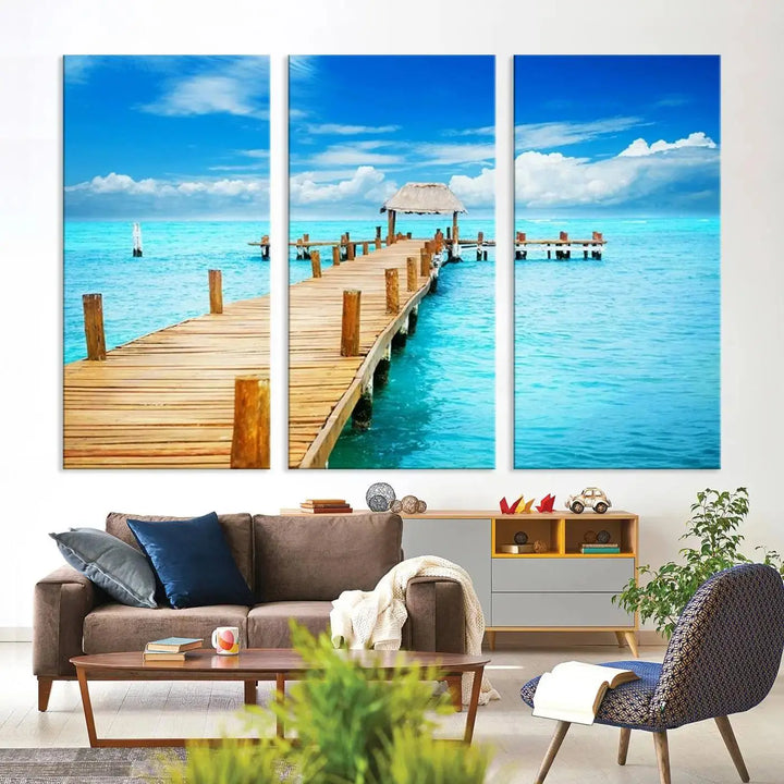 The Tropical Pier Triptych Wall Art is a captivating canvas print featuring a turquoise ocean and a wooden dock, ideal for coastal beach house decor.