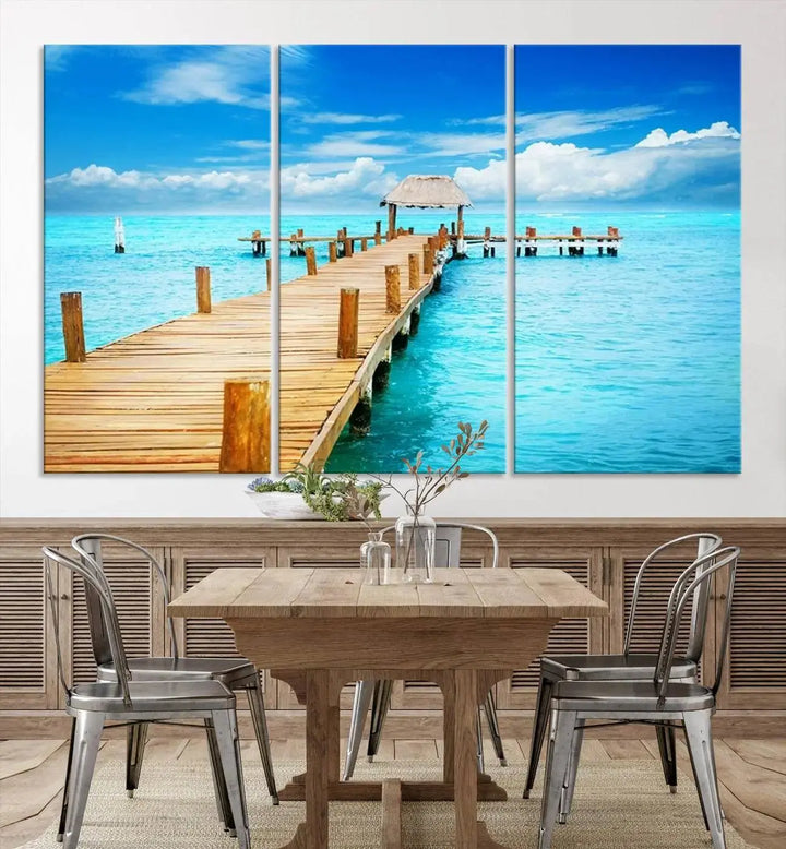 The Tropical Pier Triptych Wall Art is a captivating canvas print featuring a turquoise ocean and a wooden dock, ideal for coastal beach house decor.