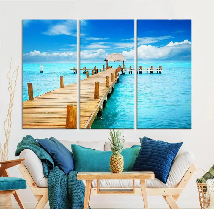 The Tropical Pier Triptych Wall Art is a captivating canvas print featuring a turquoise ocean and a wooden dock, ideal for coastal beach house decor.