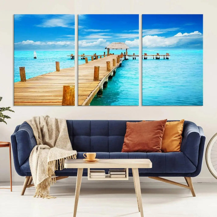 The Tropical Pier Triptych Wall Art is a captivating canvas print featuring a turquoise ocean and a wooden dock, ideal for coastal beach house decor.