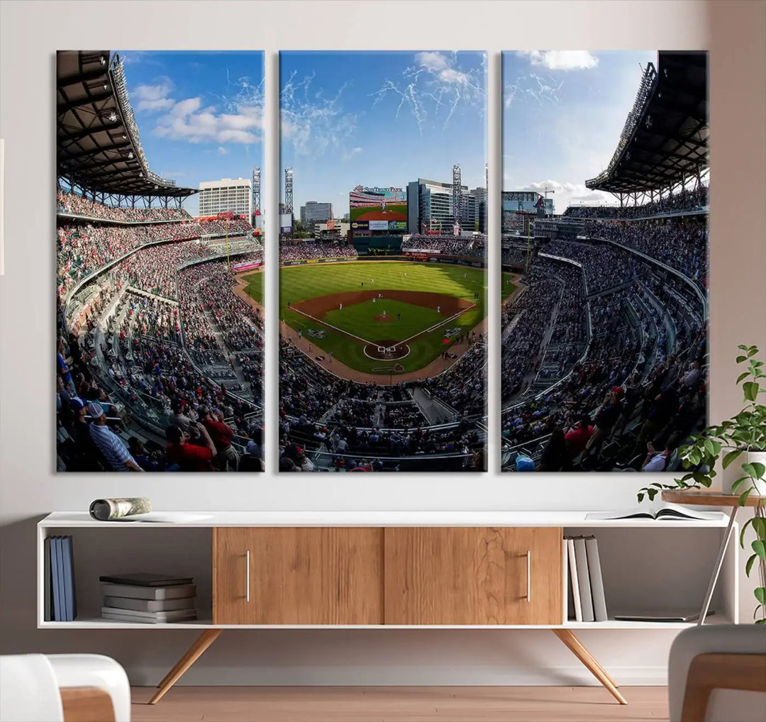 The Truist Park Stadium Triple Canvas Wall Art - Atlanta Braves Game Day Exclusive Decor beautifully adorns the wall. This three-panel arrangement captures the vibrant energy of a packed Atlanta Braves game, adding a dynamic and sporty touch to any room.