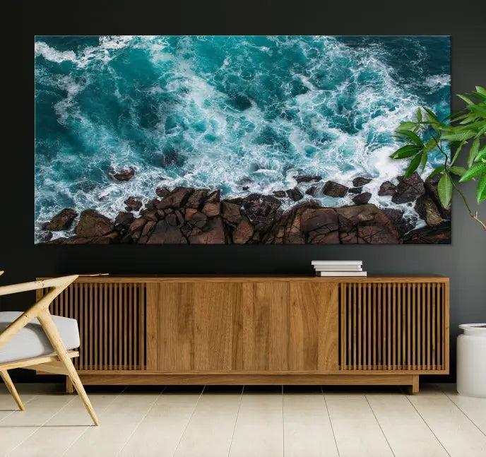 The Turquoise Aerial Wall Art Canvas Print, featuring a triptych of ocean waves crashing on rocks and printed on museum-quality canvas with a UV-protective coating, adds an exquisite touch to your living space. The gallery-wrapped pieces create a striking visual display.