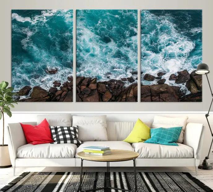 The Turquoise Aerial Wall Art Canvas Print, featuring a triptych of ocean waves crashing on rocks and printed on museum-quality canvas with a UV-protective coating, adds an exquisite touch to your living space. The gallery-wrapped pieces create a striking visual display.