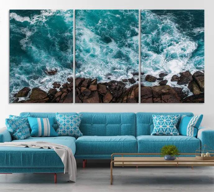 The Turquoise Aerial Wall Art Canvas Print, featuring a triptych of ocean waves crashing on rocks and printed on museum-quality canvas with a UV-protective coating, adds an exquisite touch to your living space. The gallery-wrapped pieces create a striking visual display.