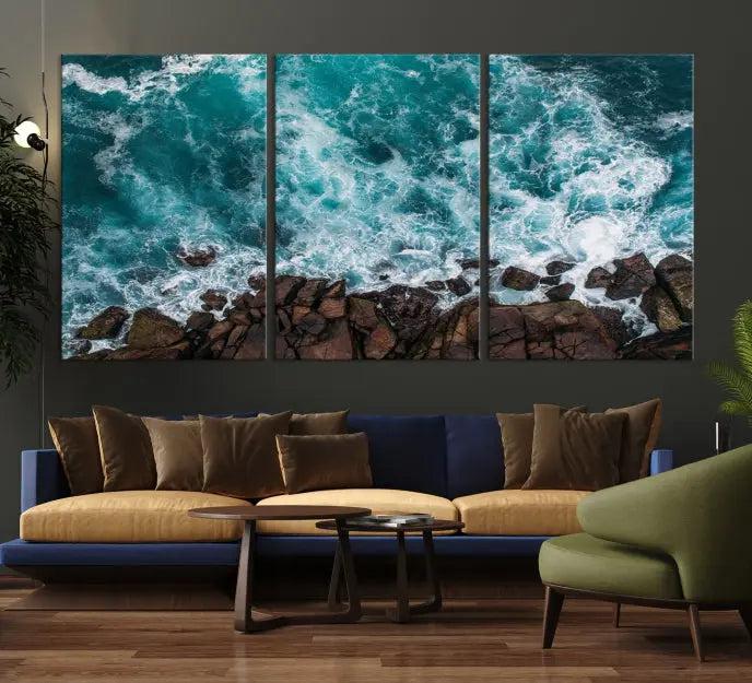 The Turquoise Aerial Wall Art Canvas Print, featuring a triptych of ocean waves crashing on rocks and printed on museum-quality canvas with a UV-protective coating, adds an exquisite touch to your living space. The gallery-wrapped pieces create a striking visual display.