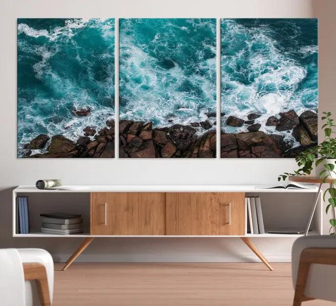 The Turquoise Aerial Wall Art Canvas Print, featuring a triptych of ocean waves crashing on rocks and printed on museum-quality canvas with a UV-protective coating, adds an exquisite touch to your living space. The gallery-wrapped pieces create a striking visual display.