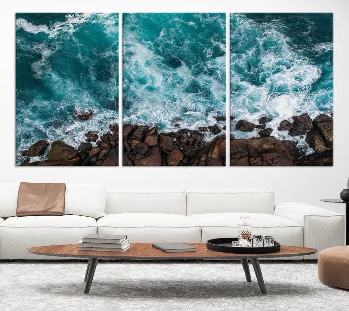 The Turquoise Aerial Wall Art Canvas Print, featuring a triptych of ocean waves crashing on rocks and printed on museum-quality canvas with a UV-protective coating, adds an exquisite touch to your living space. The gallery-wrapped pieces create a striking visual display.