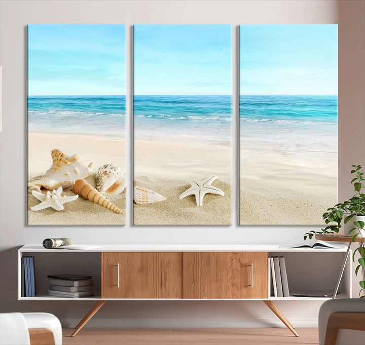 The "Turquoise Ocean View Seashell Starfish on the Beach Canvas Print Artwork" is a triptych piece that showcases a tranquil beach scene, complete with seashells and starfish adorning the sand. It is elegantly gallery-wrapped on museum-quality canvas.