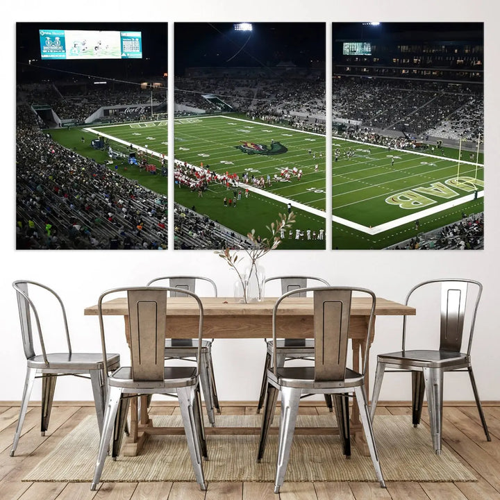 A dining area showcasing a gallery-quality triptych of the UAB Blazers Football Team Print at Birmingham Protective Stadium adorns the wall.