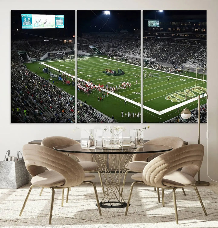 A dining area showcasing a gallery-quality triptych of the UAB Blazers Football Team Print at Birmingham Protective Stadium adorns the wall.