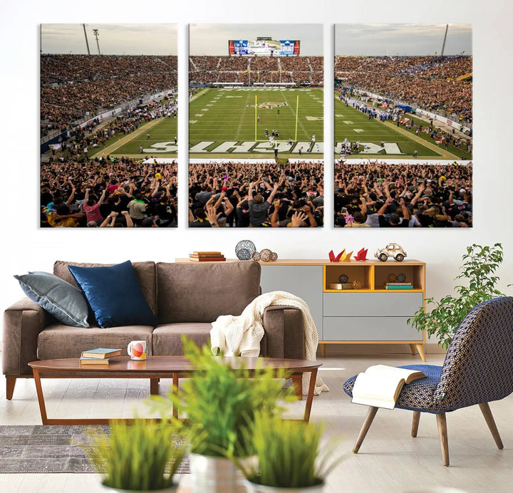 The living room features premium artwork, the "UCF Knights Football Team Print - Orlando FBC Mortgage Stadium Wall Art Canvas Print," a three-panel canvas piece depicting a bustling football stadium. Handmade in the USA, this artwork adds a dynamic and vibrant touch to your space.