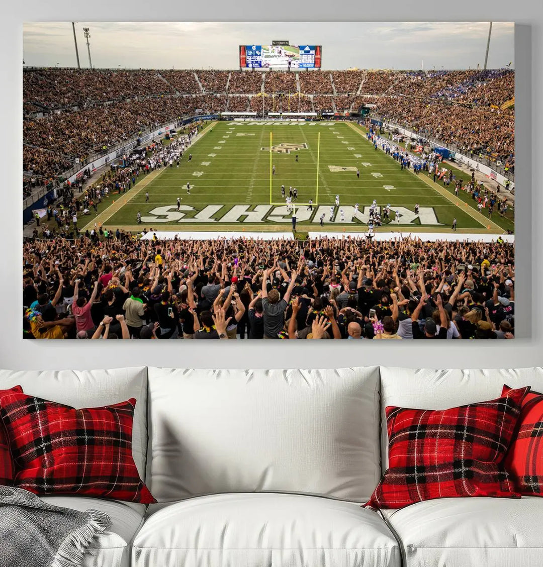 The living room features premium artwork, the "UCF Knights Football Team Print - Orlando FBC Mortgage Stadium Wall Art Canvas Print," a three-panel canvas piece depicting a bustling football stadium. Handmade in the USA, this artwork adds a dynamic and vibrant touch to your space.