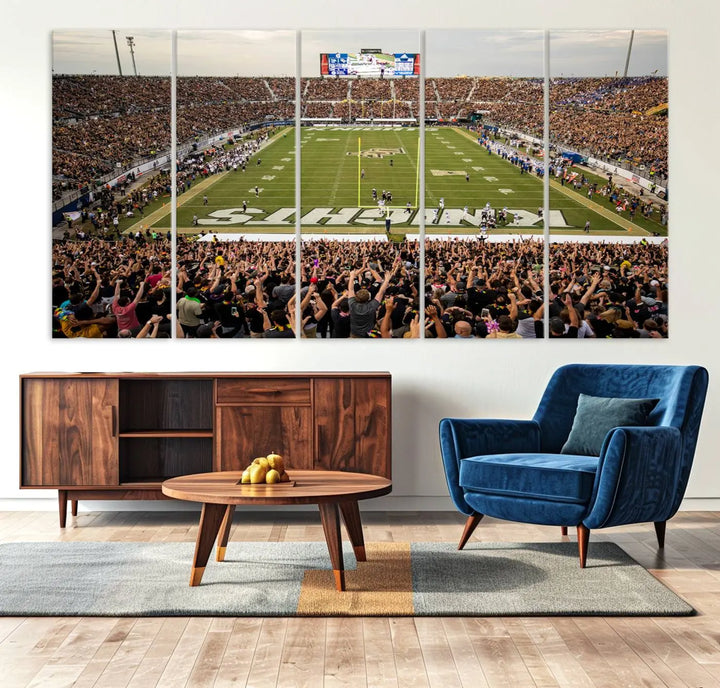 The living room features premium artwork, the "UCF Knights Football Team Print - Orlando FBC Mortgage Stadium Wall Art Canvas Print," a three-panel canvas piece depicting a bustling football stadium. Handmade in the USA, this artwork adds a dynamic and vibrant touch to your space.