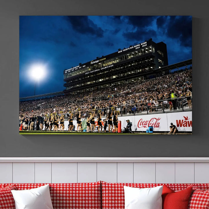 A stunning UCF Knights Football Team print is displayed, capturing the excitement of a night game at the Orlando FBC Mortgage Stadium in front of a lively crowd. This premium canvas offers a gallery-quality finish that brings the scene to life.