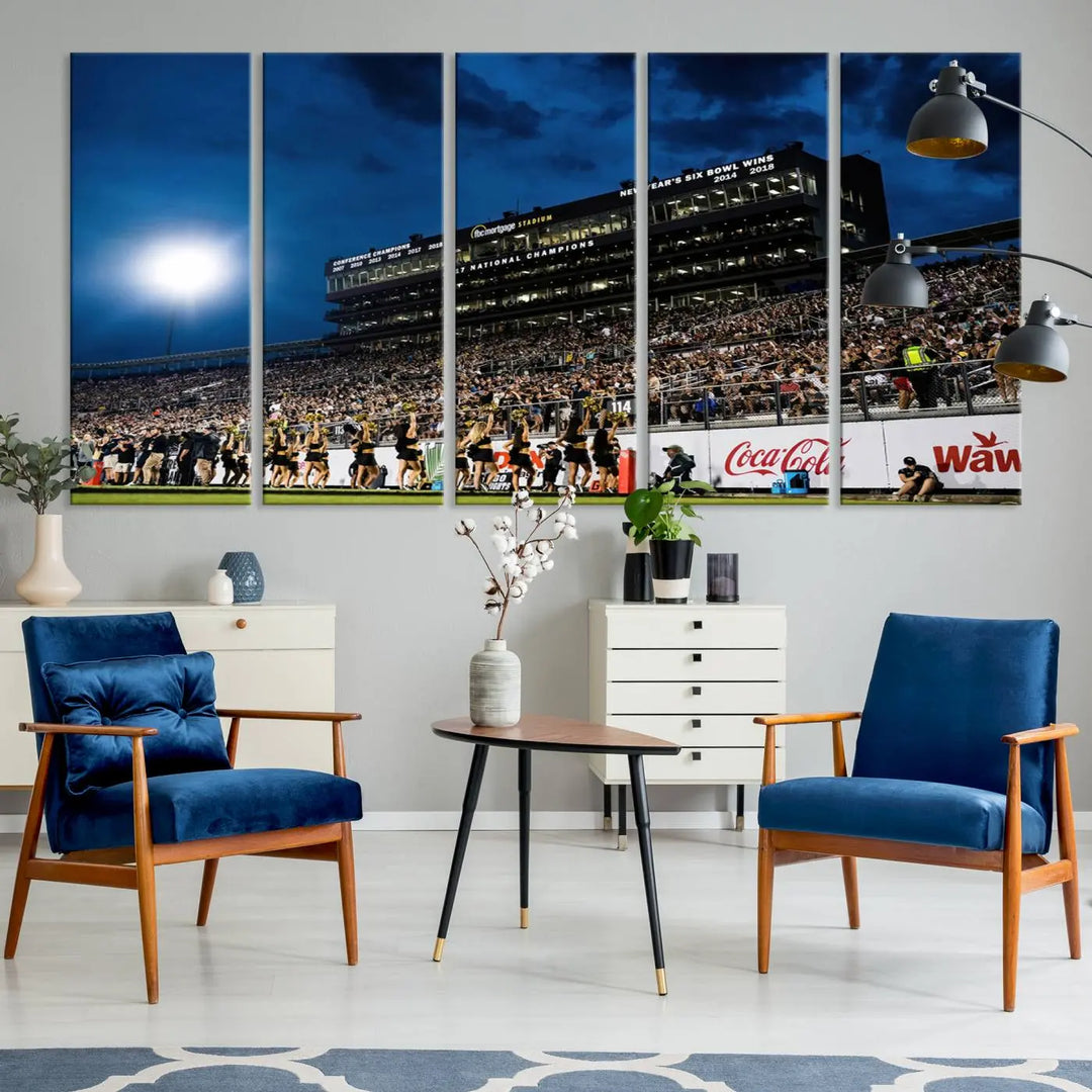 A stunning UCF Knights Football Team print is displayed, capturing the excitement of a night game at the Orlando FBC Mortgage Stadium in front of a lively crowd. This premium canvas offers a gallery-quality finish that brings the scene to life.