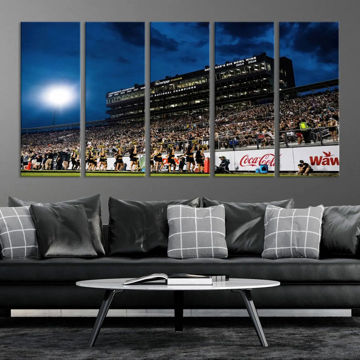 A stunning UCF Knights Football Team print is displayed, capturing the excitement of a night game at the Orlando FBC Mortgage Stadium in front of a lively crowd. This premium canvas offers a gallery-quality finish that brings the scene to life.