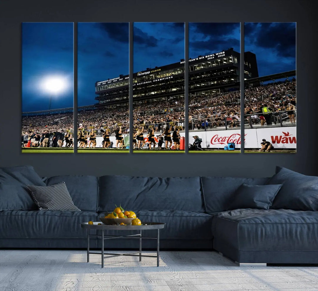 A stunning UCF Knights Football Team print is displayed, capturing the excitement of a night game at the Orlando FBC Mortgage Stadium in front of a lively crowd. This premium canvas offers a gallery-quality finish that brings the scene to life.