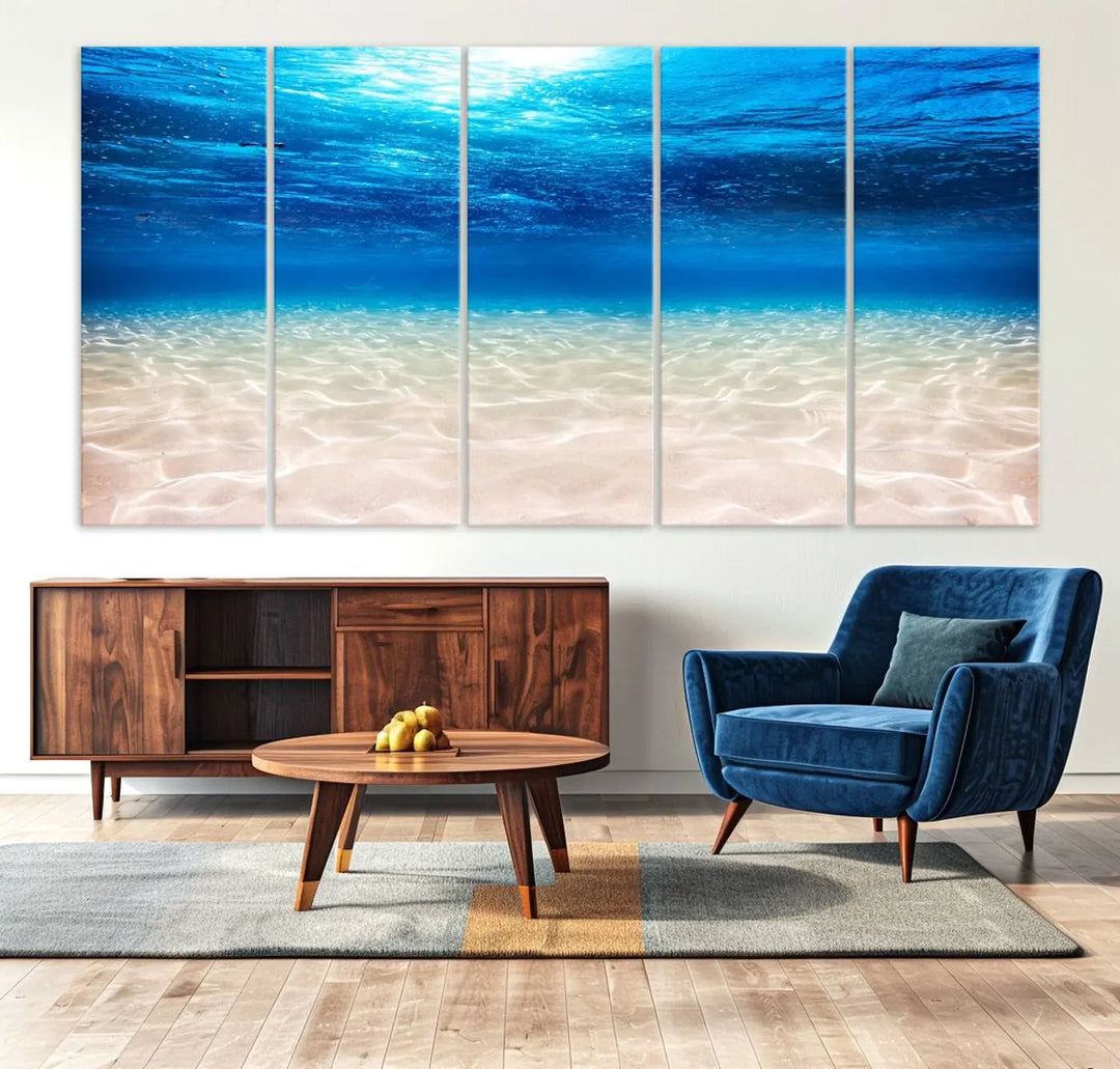 The "Underwater Ocean Scene Giclee Canvas Print – Serene Deep Blue Seascape Wall Art for Coastal Home Decor, Tranquil Sea Bottom Landscape" is gracefully mounted on a wooden wall, creating the perfect marine-themed home decor with its depiction of sunlight illuminating the sandy ocean floor.