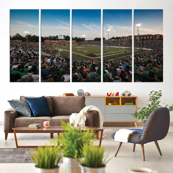 Above the dining table hangs a premium canvas triptych depicting Charlotte Jerry Richardson Stadium, home of the University of Charlotte 49ers Football Team. The scene is alive with a nighttime atmosphere, bustling with a large crowd under bright stadium lights. This stunning art piece is expertly handmade in the USA and adds vibrant energy to your living space.