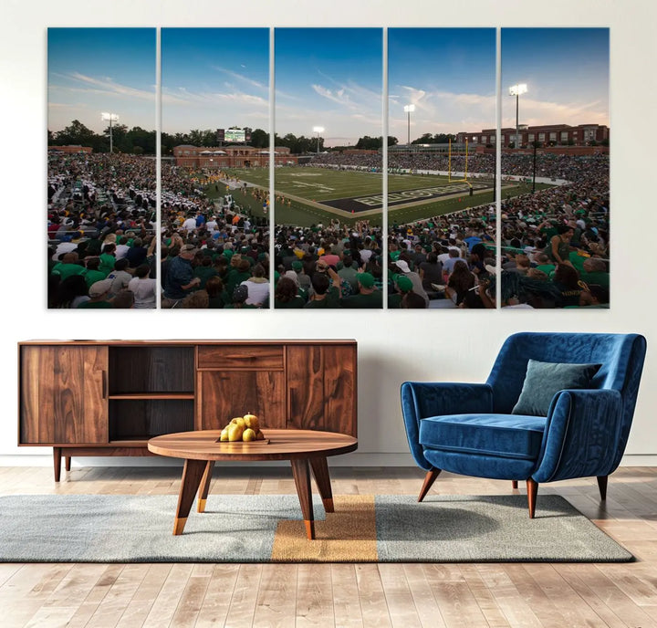 Above the dining table hangs a premium canvas triptych depicting Charlotte Jerry Richardson Stadium, home of the University of Charlotte 49ers Football Team. The scene is alive with a nighttime atmosphere, bustling with a large crowd under bright stadium lights. This stunning art piece is expertly handmade in the USA and adds vibrant energy to your living space.