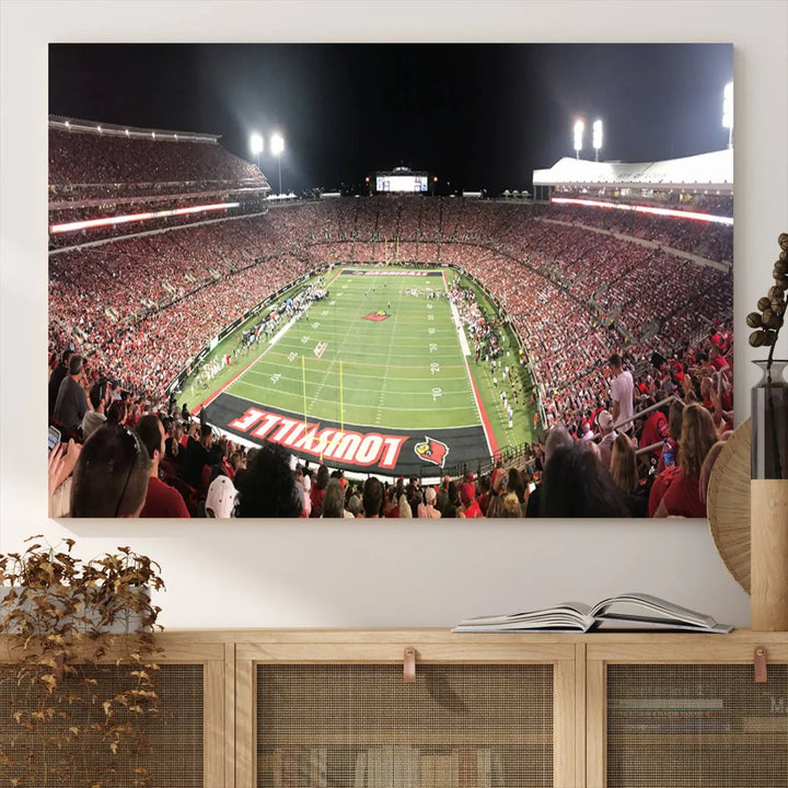 A canvas print featuring the University of Louisville Cardinals Football Team and a bustling Cardinal Stadium at night adorns the wall.