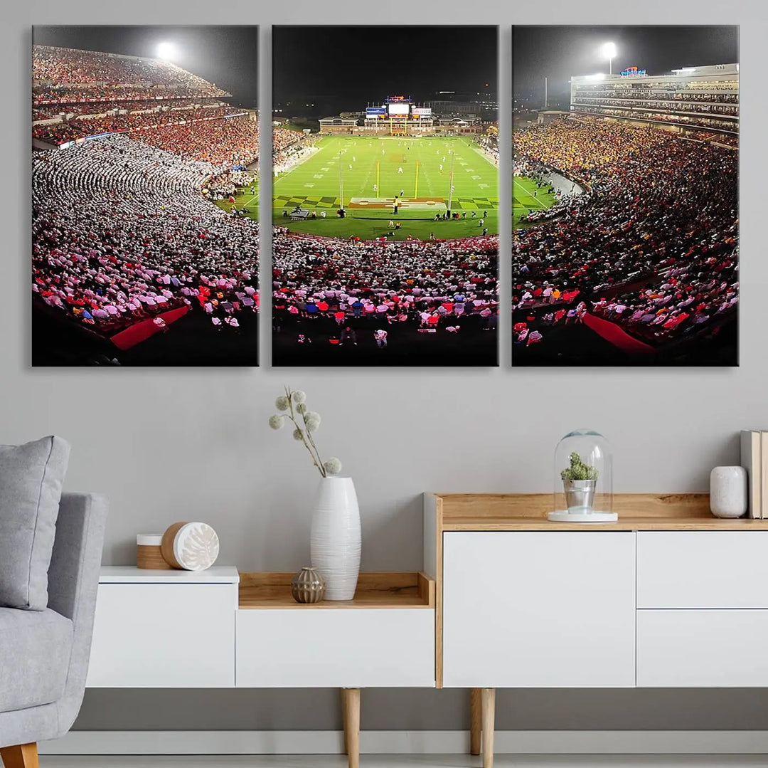 A University of Maryland Terrapins Football Team Print, featuring the College Park SECU Stadium at night, printed on premium canvas with a gallery-quality finish, enhances a modern living room.