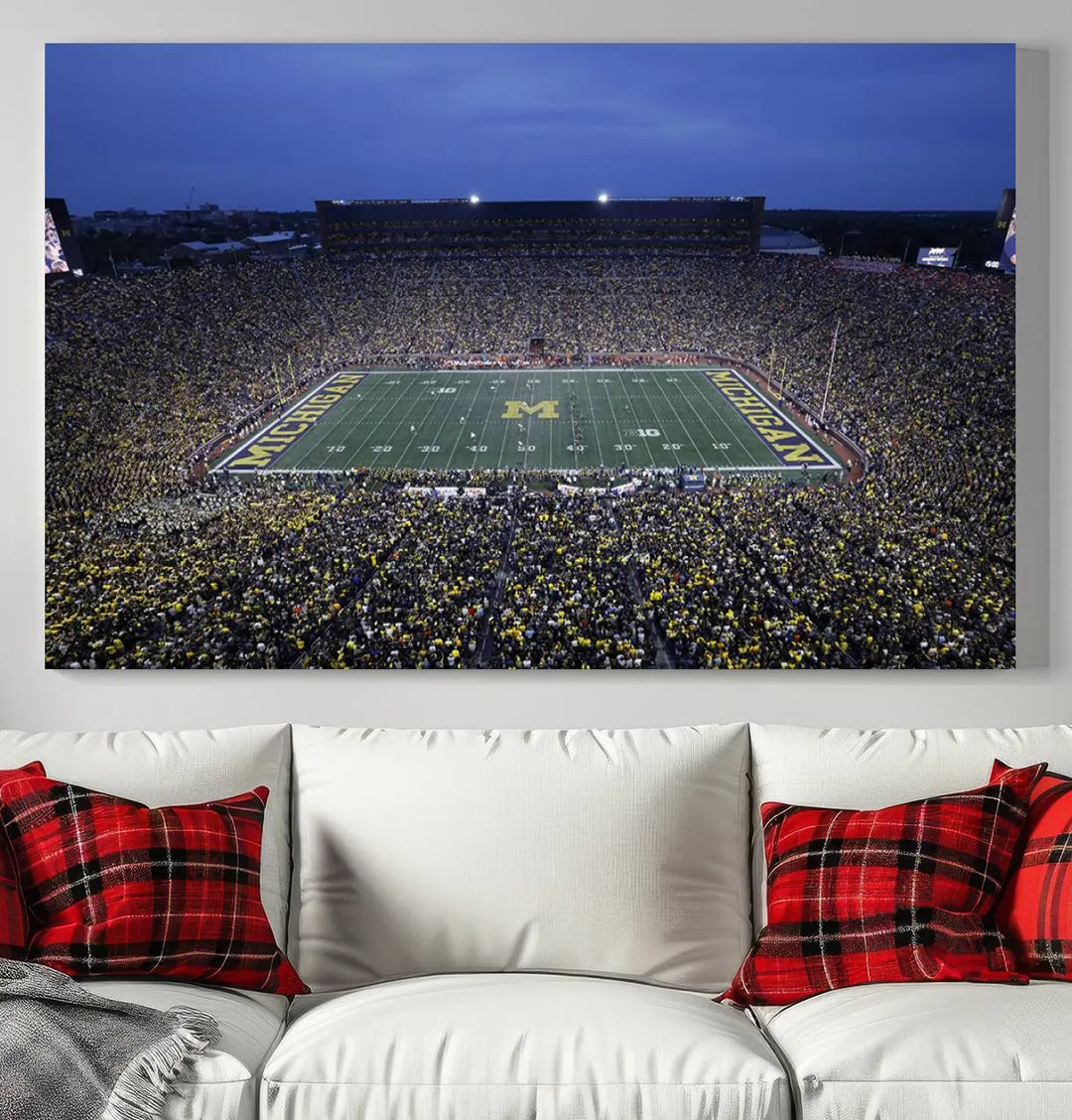 Experience the excitement and grandeur of a packed football stadium at night with this University of Michigan Wolverines Football Team Print. Featuring a panoramic view of the iconic Ann Arbor Michigan Stadium and its green field adorned with a large M logo, this canvas artwork offers a gallery-quality finish that brings an energetic moment into your space.