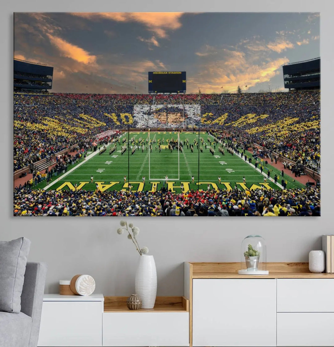 A living room showcases the University of Michigan Wolverines Football Team Print - Ann Arbor Michigan Stadium Wall Art Canvas Print in a triptych style. This stunning piece features a gallery-quality finish on premium canvas, infusing elegance into the space.