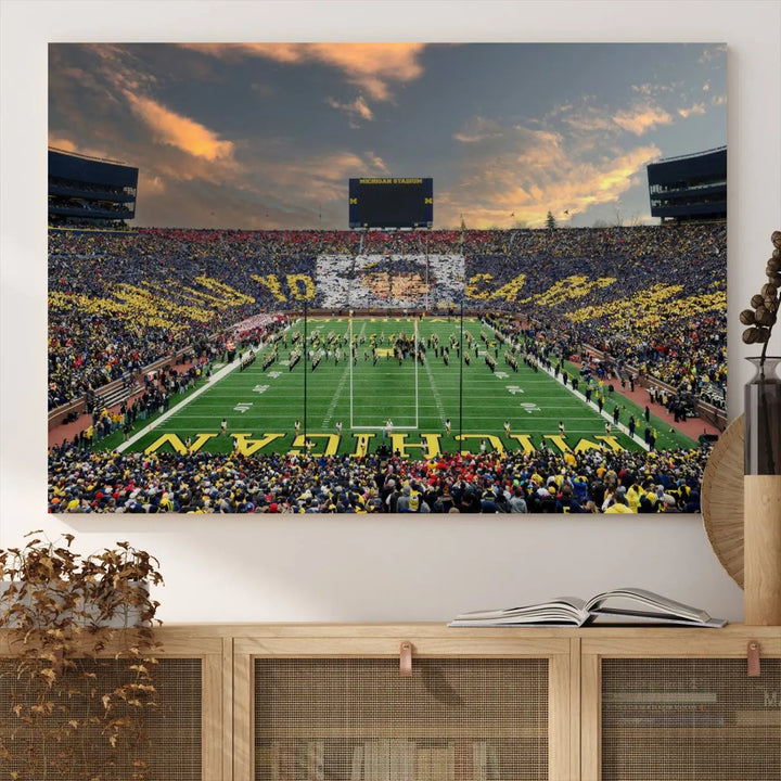 A living room showcases the University of Michigan Wolverines Football Team Print - Ann Arbor Michigan Stadium Wall Art Canvas Print in a triptych style. This stunning piece features a gallery-quality finish on premium canvas, infusing elegance into the space.