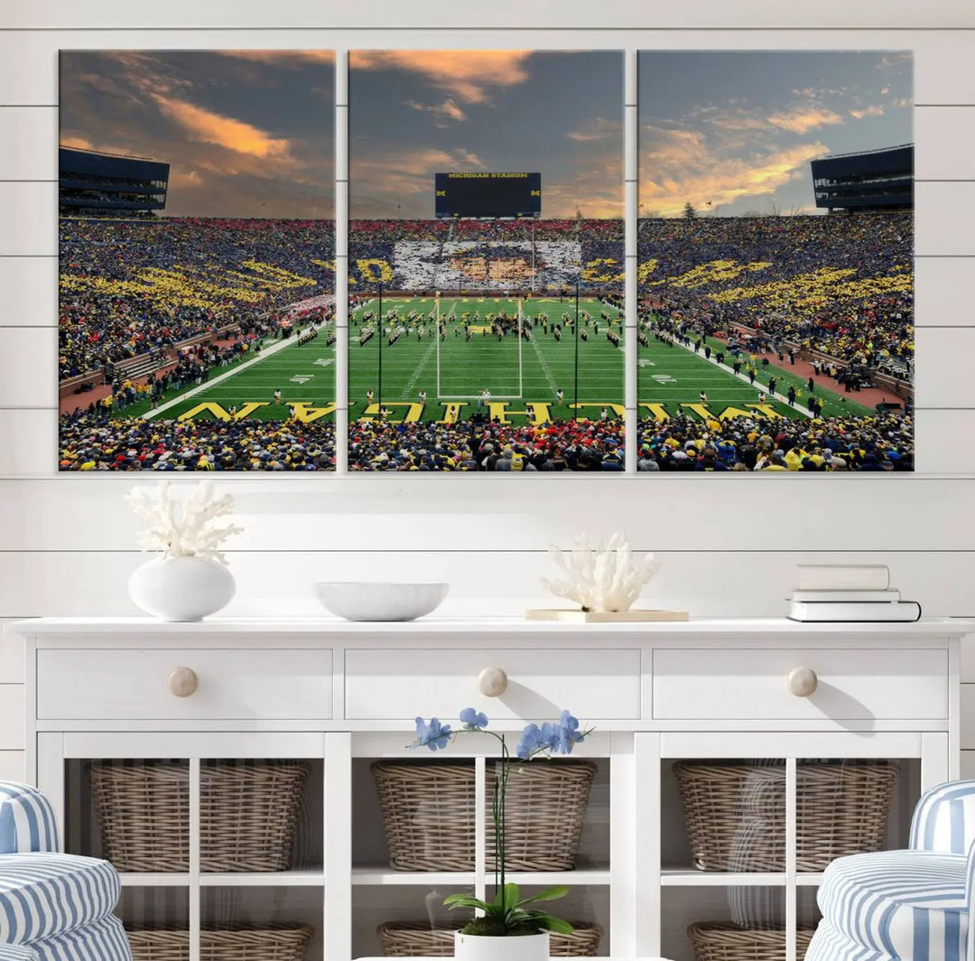 A living room showcases the University of Michigan Wolverines Football Team Print - Ann Arbor Michigan Stadium Wall Art Canvas Print in a triptych style. This stunning piece features a gallery-quality finish on premium canvas, infusing elegance into the space.