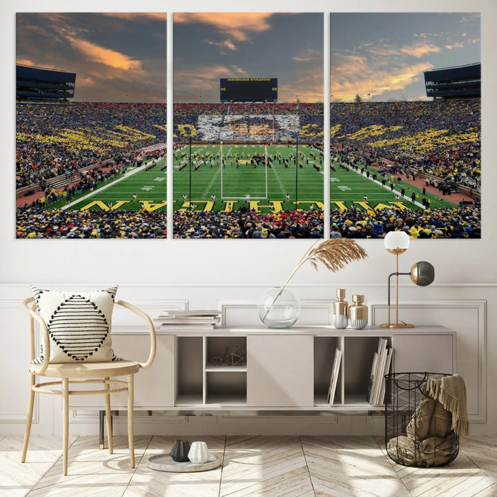 A living room showcases the University of Michigan Wolverines Football Team Print - Ann Arbor Michigan Stadium Wall Art Canvas Print in a triptych style. This stunning piece features a gallery-quality finish on premium canvas, infusing elegance into the space.