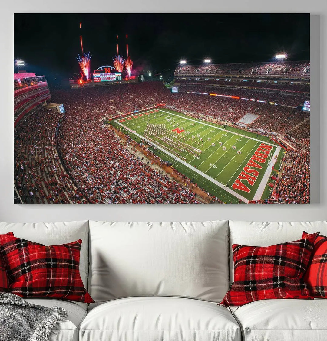 The University of Nebraska Cornhuskers Football Team Print, featuring Lincoln Memorial Stadium in a vibrant triptych canvas with fireworks above and a gallery-quality finish, is elegantly displayed.