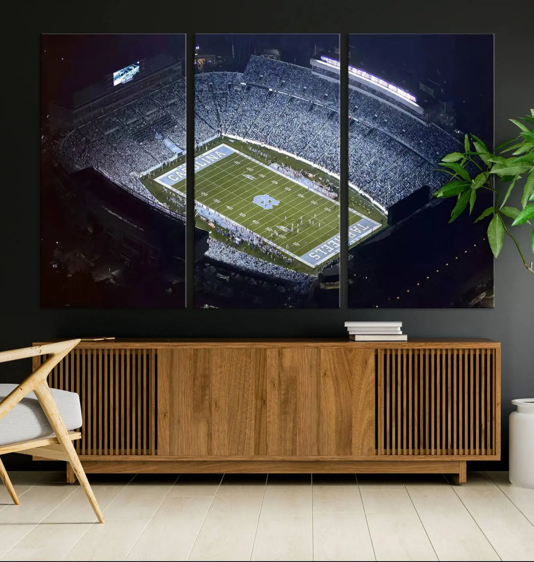 A University of North Carolina Tar Heels Football Team Print, showcasing Chapel Hill's Kenan Memorial Stadium, hangs in a modern dining room, adding a gallery-quality finish that enhances the entire space.