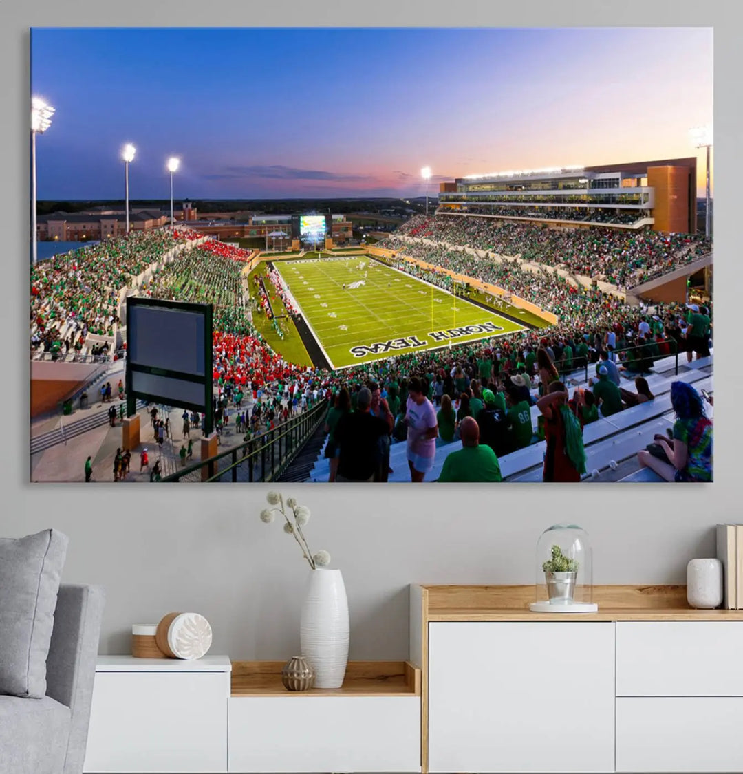 A panoramic triptych of the University of North Texas Mean Green Football Team in a packed Denton DATCU Stadium under evening lights, mounted as premium canvas wall art.