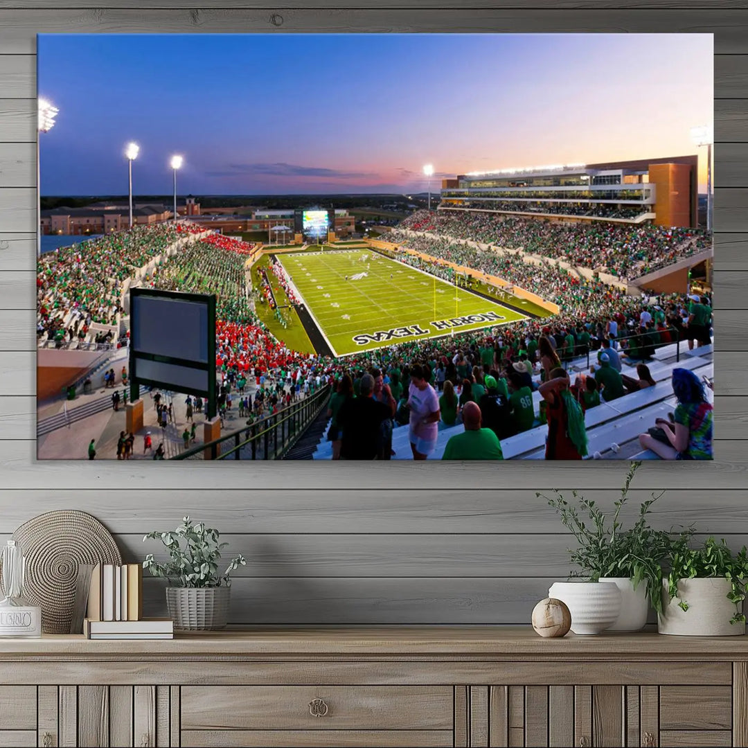 A panoramic triptych of the University of North Texas Mean Green Football Team in a packed Denton DATCU Stadium under evening lights, mounted as premium canvas wall art.