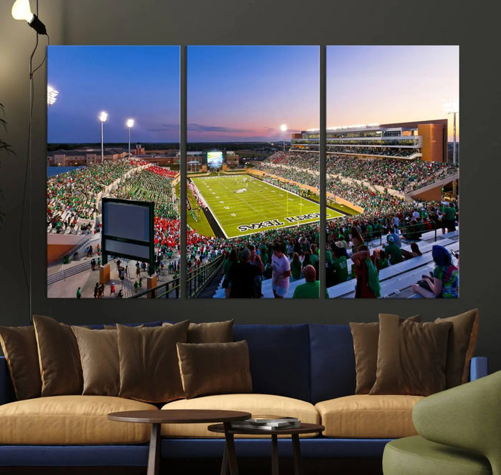 A panoramic triptych of the University of North Texas Mean Green Football Team in a packed Denton DATCU Stadium under evening lights, mounted as premium canvas wall art.