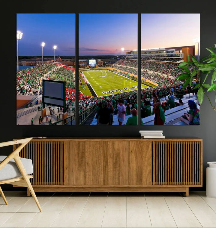 A panoramic triptych of the University of North Texas Mean Green Football Team in a packed Denton DATCU Stadium under evening lights, mounted as premium canvas wall art.