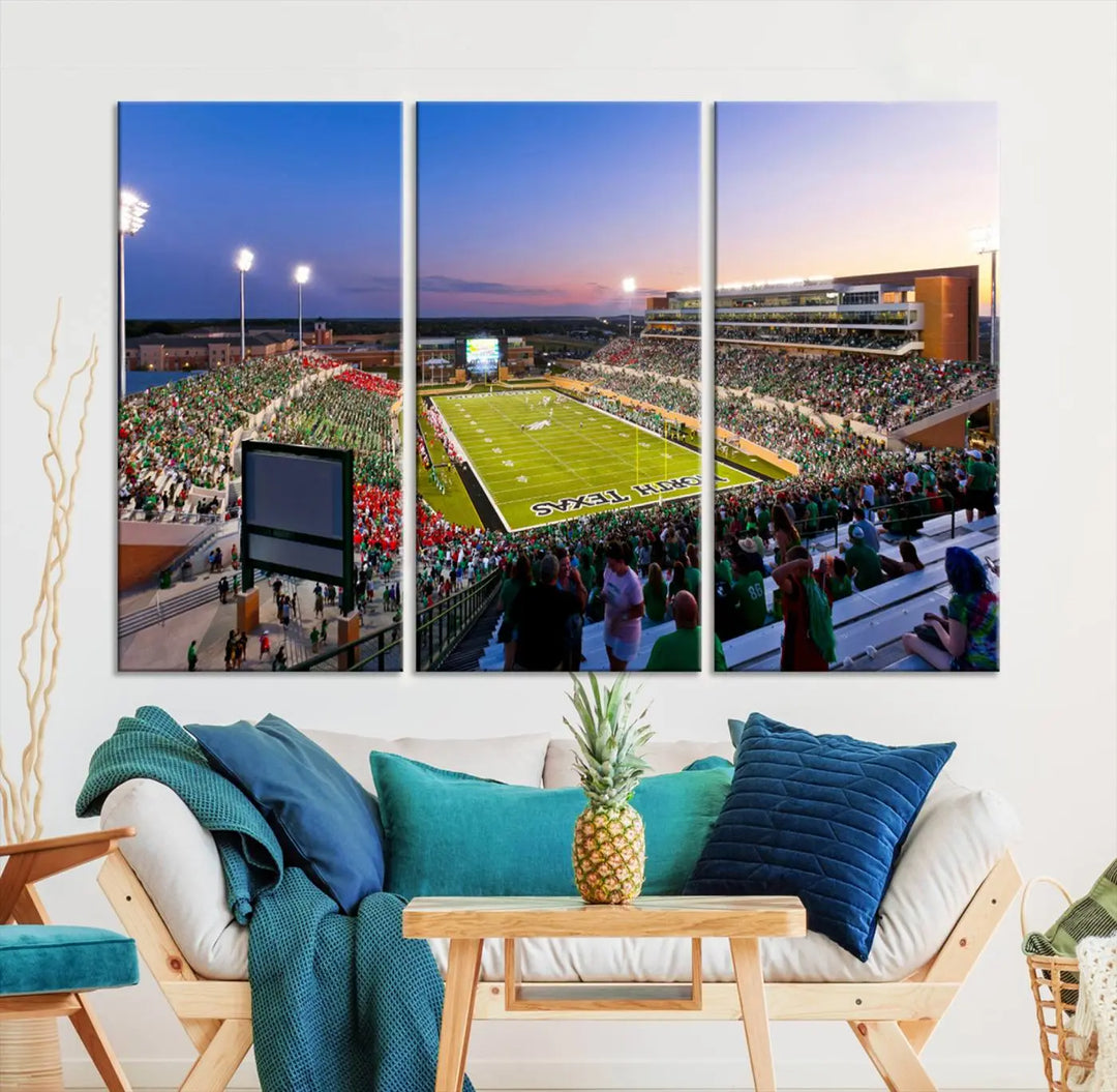 A panoramic triptych of the University of North Texas Mean Green Football Team in a packed Denton DATCU Stadium under evening lights, mounted as premium canvas wall art.