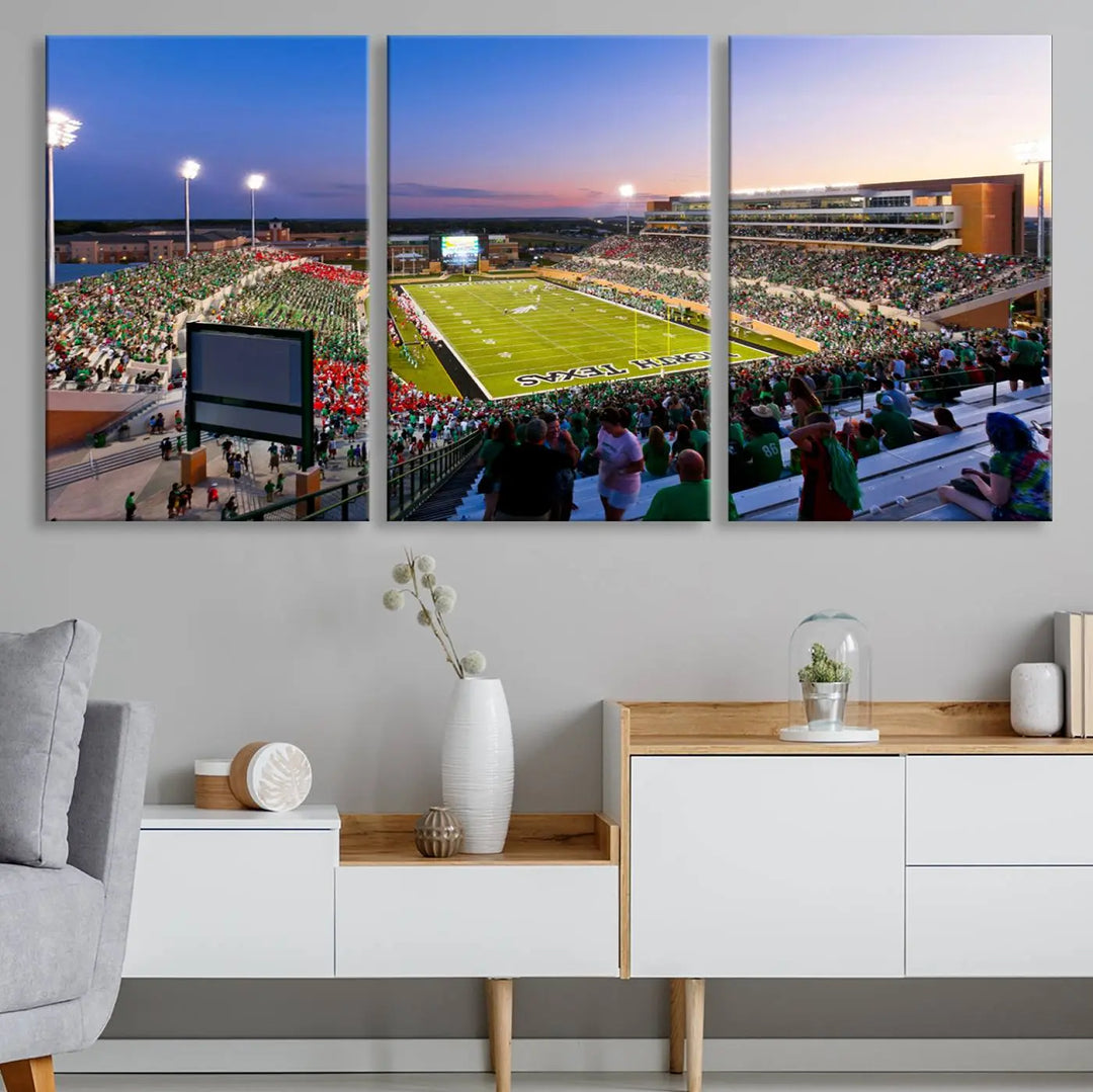 A panoramic triptych of the University of North Texas Mean Green Football Team in a packed Denton DATCU Stadium under evening lights, mounted as premium canvas wall art.