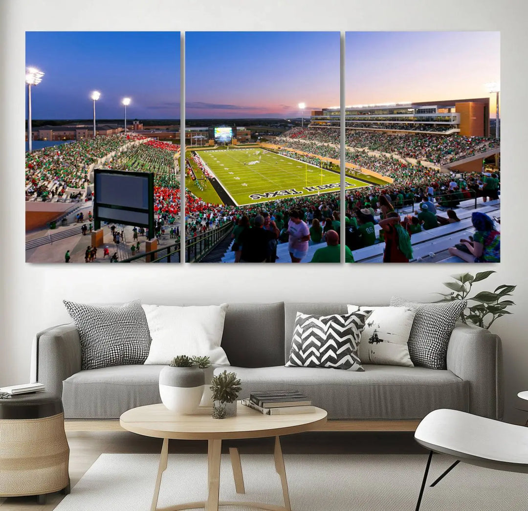 A panoramic triptych of the University of North Texas Mean Green Football Team in a packed Denton DATCU Stadium under evening lights, mounted as premium canvas wall art.