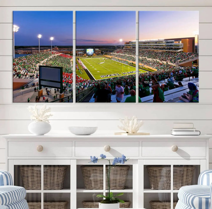 A panoramic triptych of the University of North Texas Mean Green Football Team in a packed Denton DATCU Stadium under evening lights, mounted as premium canvas wall art.