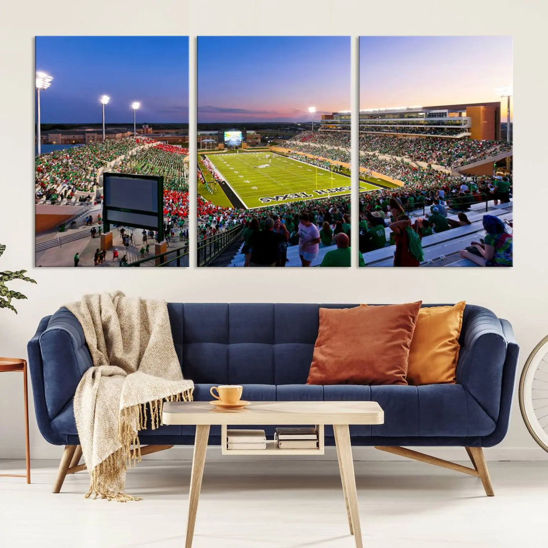 A panoramic triptych of the University of North Texas Mean Green Football Team in a packed Denton DATCU Stadium under evening lights, mounted as premium canvas wall art.