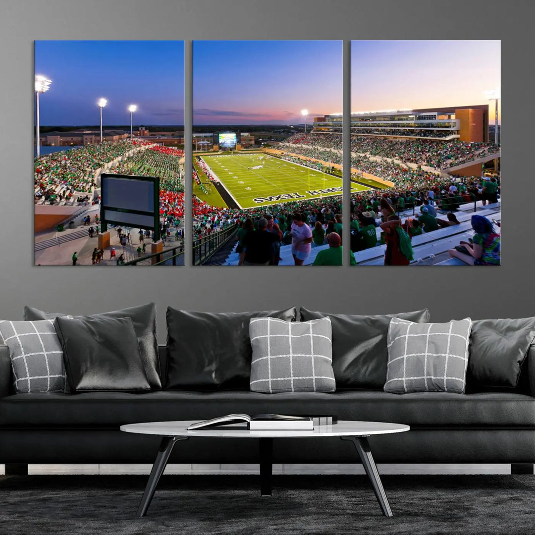 A panoramic triptych of the University of North Texas Mean Green Football Team in a packed Denton DATCU Stadium under evening lights, mounted as premium canvas wall art.