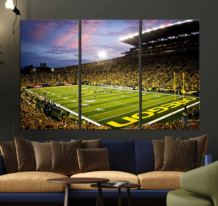 The living room showcases a triptych titled "University of Oregon Ducks Football Team Print - Eugene Autzen Stadium Wall Art Canvas Print," exhibiting a football stadium at sunset with a premium gallery-quality finish.