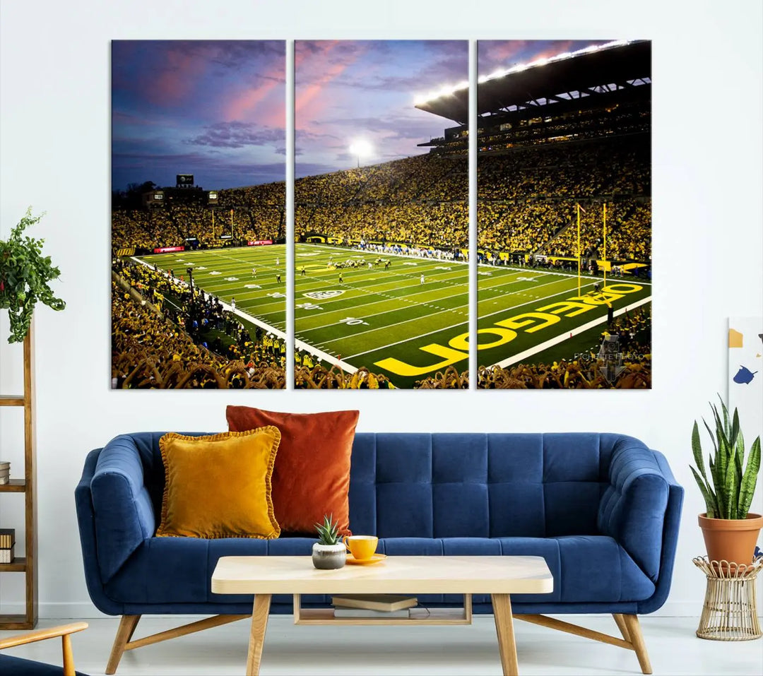 The living room showcases a triptych titled "University of Oregon Ducks Football Team Print - Eugene Autzen Stadium Wall Art Canvas Print," exhibiting a football stadium at sunset with a premium gallery-quality finish.