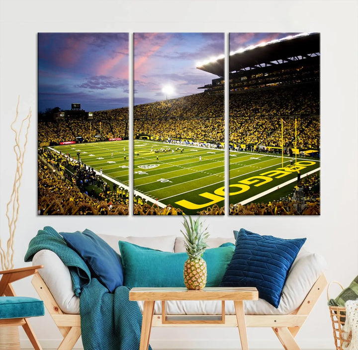 The living room showcases a triptych titled "University of Oregon Ducks Football Team Print - Eugene Autzen Stadium Wall Art Canvas Print," exhibiting a football stadium at sunset with a premium gallery-quality finish.